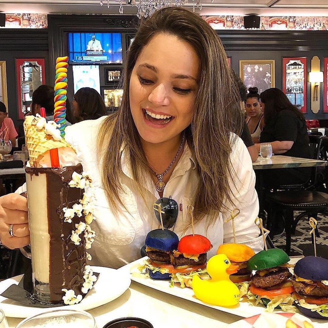 imagem de uma moca provando os hamburgueres e o milkshake da sugar factory