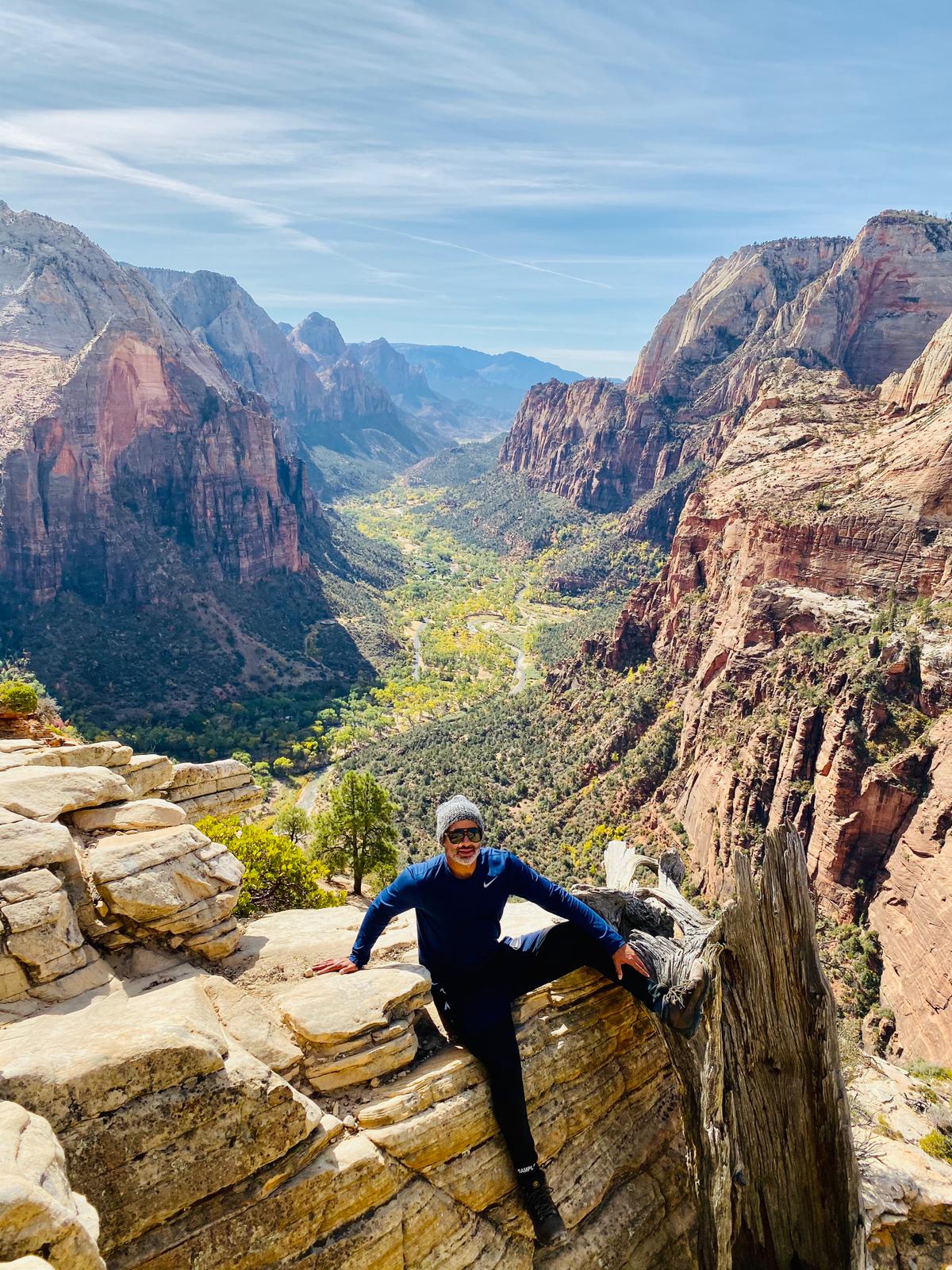 imagem de um homem sentado em uma das pedras que ficam no zion canyon no parque nos estados unidos