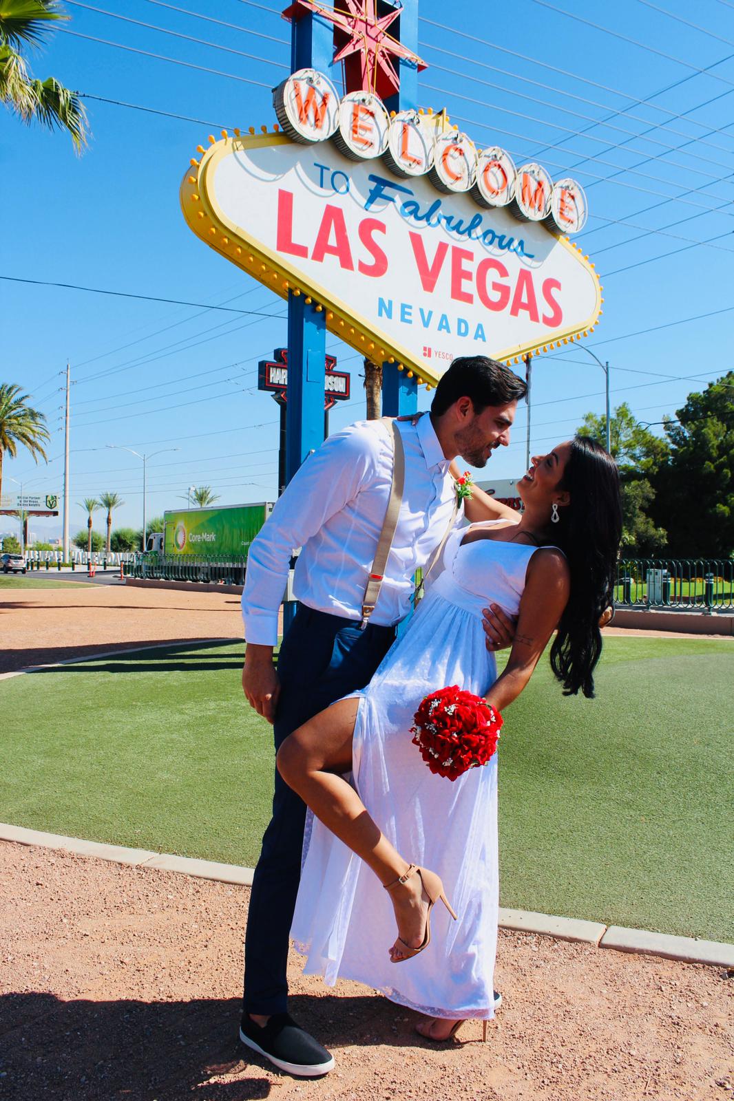 imagem de um casal de noivos casando-se em frente a placa de vegas