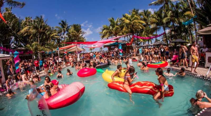 pessoas curtindo o verao na piscina do hotel